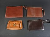 four different types of leather wallets on a black surface