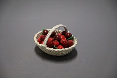 a small basket of cherries sitting on a table