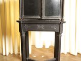 a black table with a mirror on it in front of a curtain
