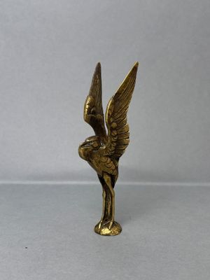 a gold statue of a bird with wings on it ' s head
