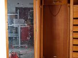 a wooden cabinet with a mirror and a red fire hydrant in it