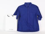 blue button up shirt next to a white shopping bag on a white surface