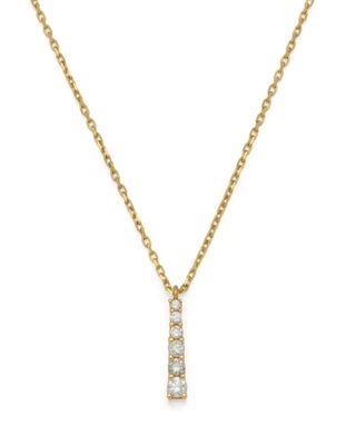 a gold necklace with a diamond bar pendant on a chain