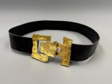 a close up of a black belt with a gold buckle