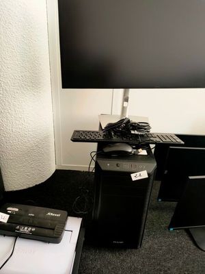 a desk with a computer, keyboard, and monitor on it