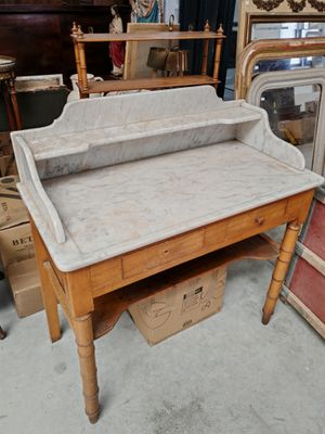 un bureau en bois avec un plateau en marbre, dans une pièce remplie de meubles anciens