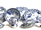 many blue and white plates and cups on the table
