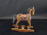 cheval à bascule en bois sculpté sur fond noir avec un fond gris