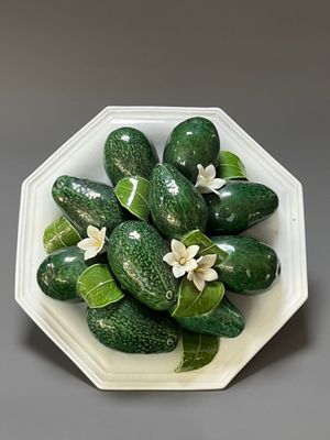 des concombres dans un saladier blanc, accompagnés de feuilles vertes et de fleurs