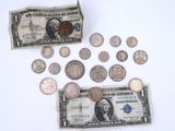 a lot of coins and a dollar sitting on a table