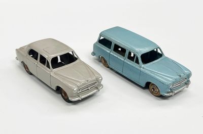 deux voitures jouets assises l'une à côté de l'autre sur une surface blanche