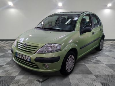 une photo d'une petite voiture verte garée dans un garage