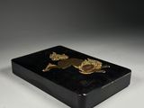 a black and gold box with two gold turtles on it
