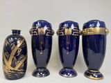 three blue vases with gold designs are lined up on a white surface