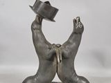 statue of two bears with hats on their heads on a marble base