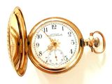 une montre de poche en or posée sur une surface blanche