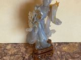 une statue représentant une femme tenant un éventail, posée sur une table