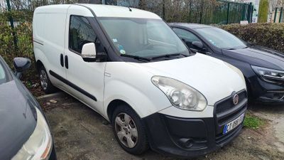une camionnette blanche garée dans un parking à côté d'autres voitures
