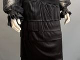an image of a mannequin wearing a black dress with sheer sleeves