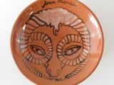 a ceramic bowl with a drawing of a woman ' s face on it