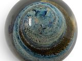 a close up of a blue and brown glass object on a white surface