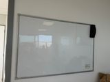 a white board hanging on the wall in a room