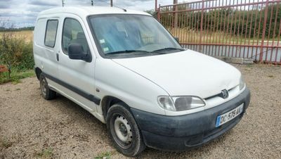 une camionnette blanche garée dans la poussière