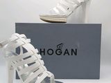 Cette chaussure est blanche, dotée d'un talon haut et d'un design en forme de cage.