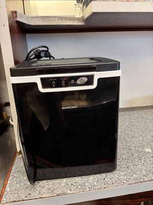 a small black dishwasher sitting on top of a counter