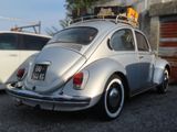 a silver vw beetle parked in front of a building