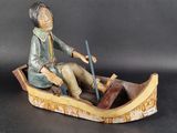 a figurine of a man in a boat on a table