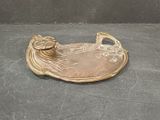 a gold plate with a bird on it sitting on a table