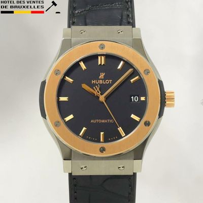 La montre est noire et dorée, avec un cadran noir.