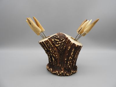 wooden utensils in a tree stump holder on a gray background