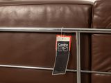 brown leather couch with a price tag attached to the back of it