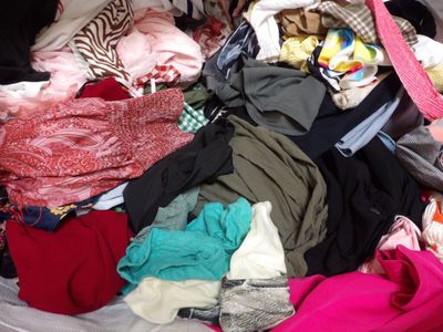 a large pile of clothes in a suitcase on the floor