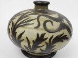 a black and white vase sitting on a white surface