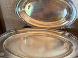 deux plateaux en métal argenté posés sur une table en bois, avec une étiquette de prix