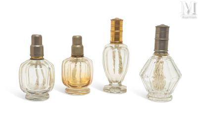 three small bottles of perfume are lined up on a white surface