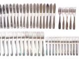a lot of forks and knives on a white surface