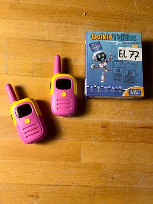 deux talkies-walkies roses et jaunes posés sur une table en bois