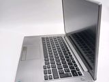 a silver laptop with a black keyboard on a white surface