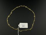 a close up of a gold chain bracelet with a tag on it