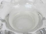 a clear glass bowl with a silver rim on a table