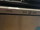 a silver dishwasher sitting on top of a white counter