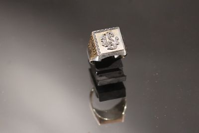 une image d'une bague en diamant sur une surface réfléchissante