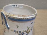 a white cup with a blue handle sitting on a table