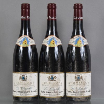 trois bouteilles de vin sont alignées sur une table