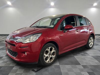 une citrole rouge garee sur un plancher en damier dans un garage