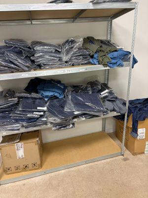 beaucoup de chemises bleues sur une étagère dans une pièce